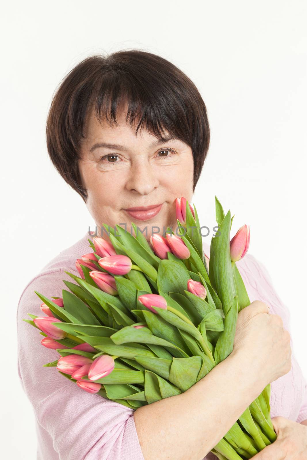 the beautiful mature woman with a bouquet of tulips