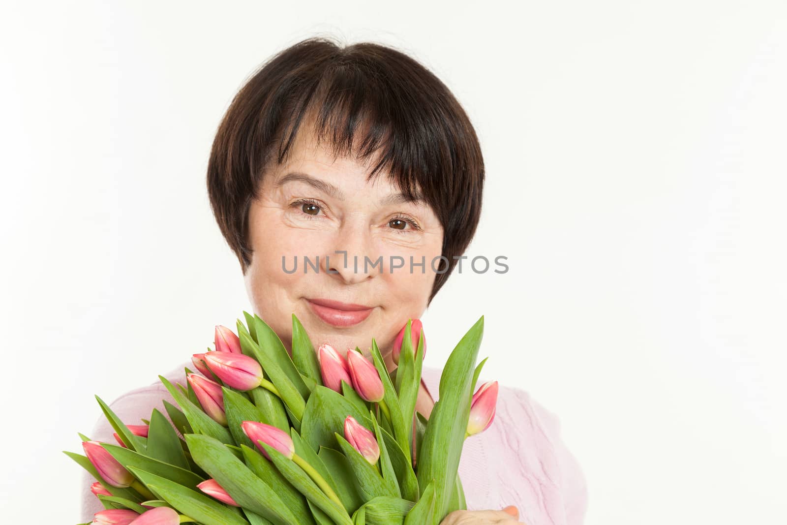 the beautiful mature woman with a bouquet of tulips