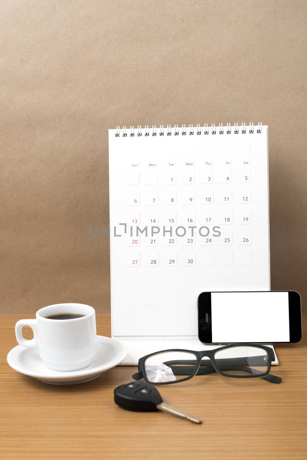 coffee,phone,car key,eyeglasses and calendar on wood table background