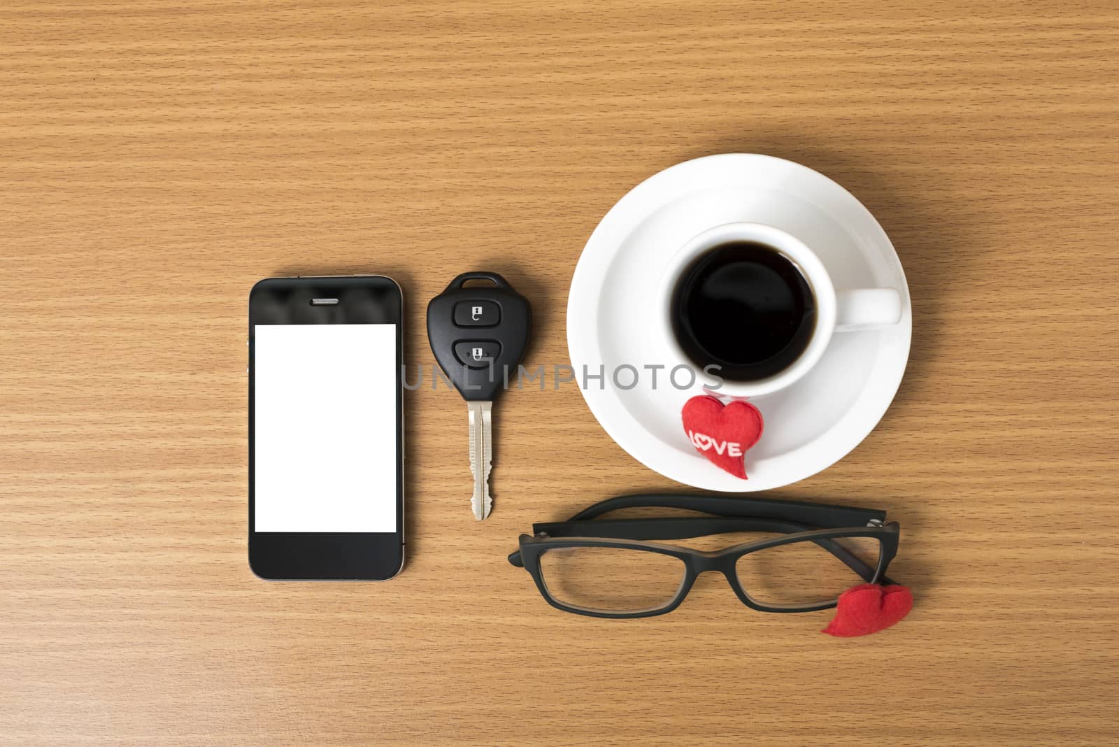 coffee,phone,eyeglasses,car key and heart on wood table background