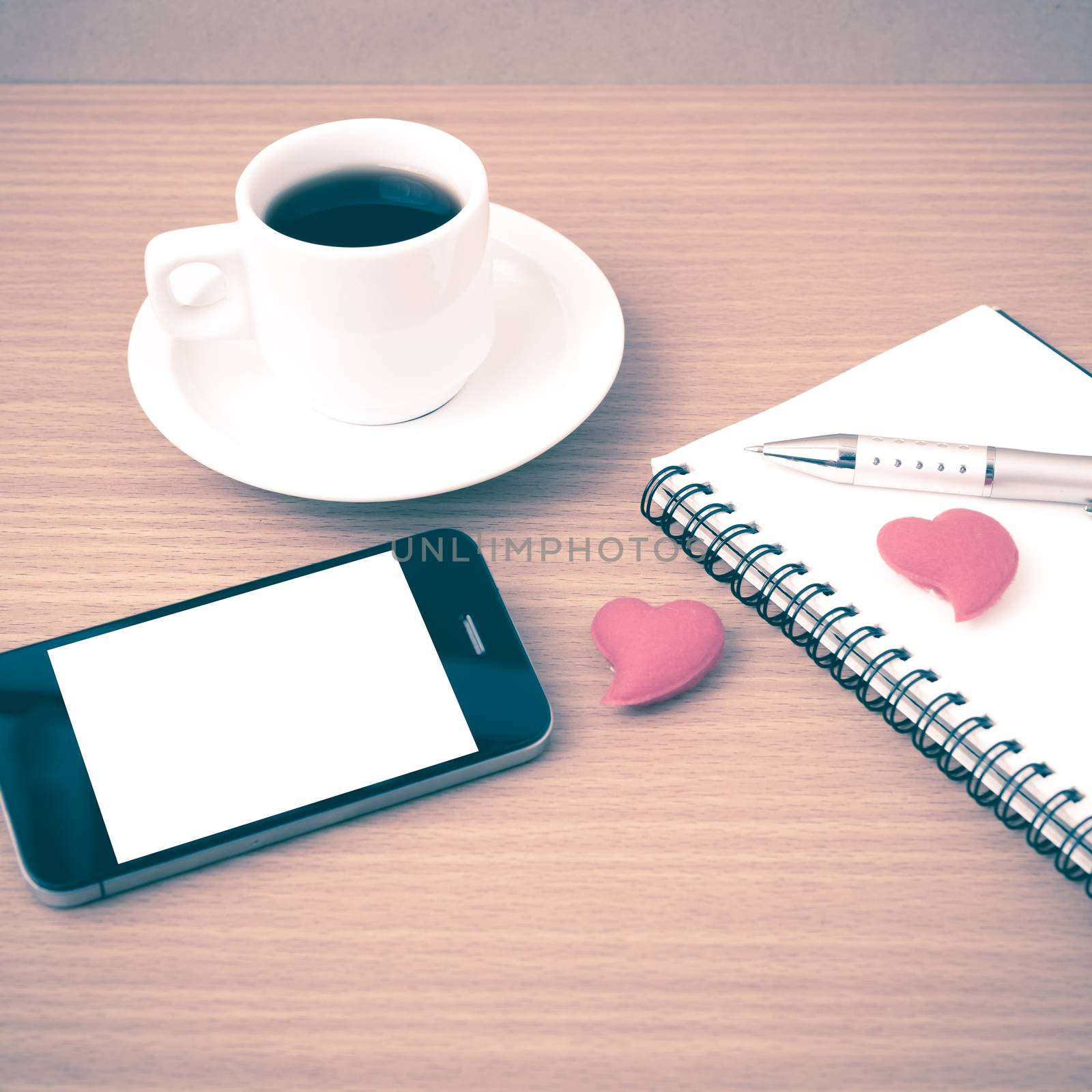 coffee,phone,notepad and heart on wood table background vintage style