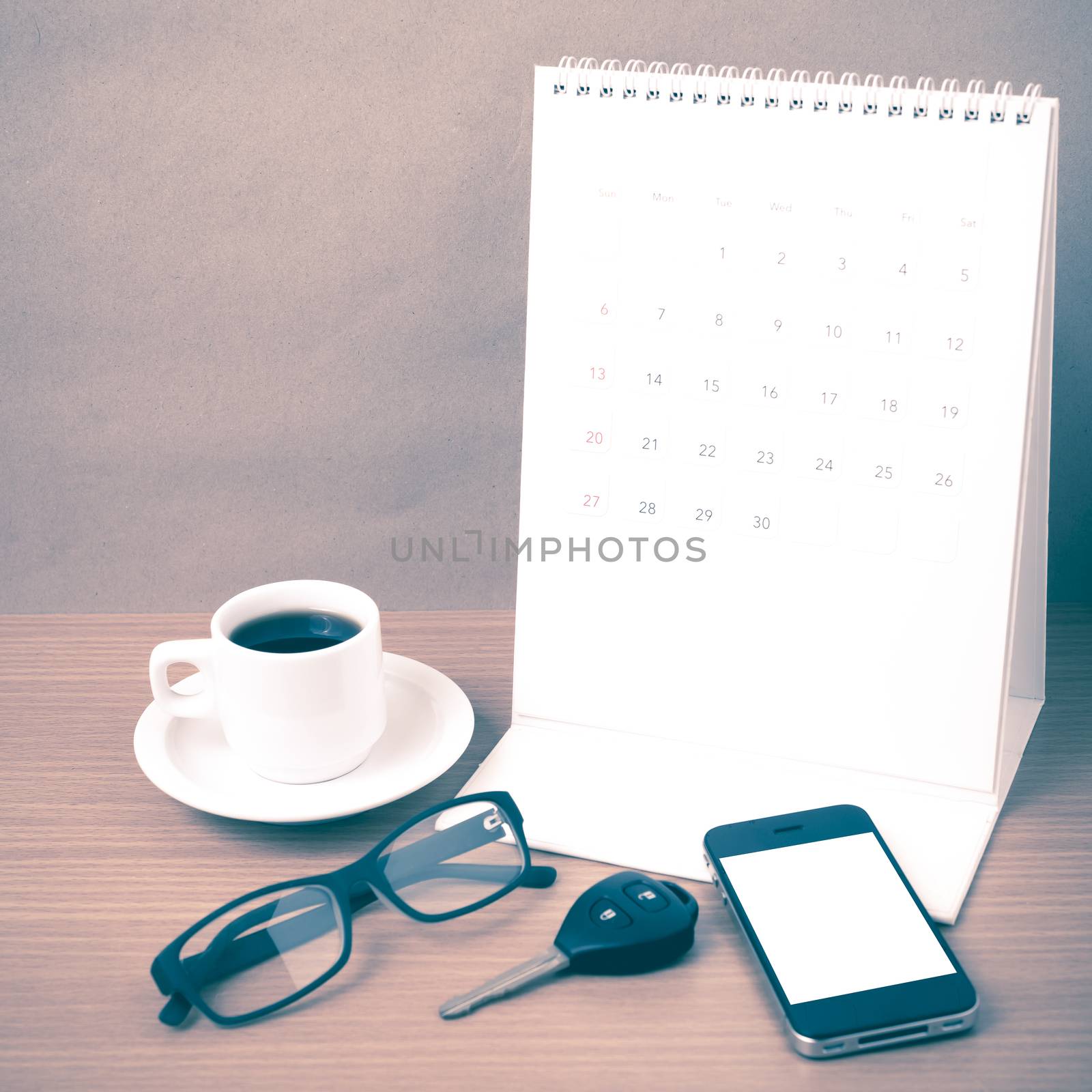 coffee,phone,car key,eyeglasses and calendar on wood table background vintage style