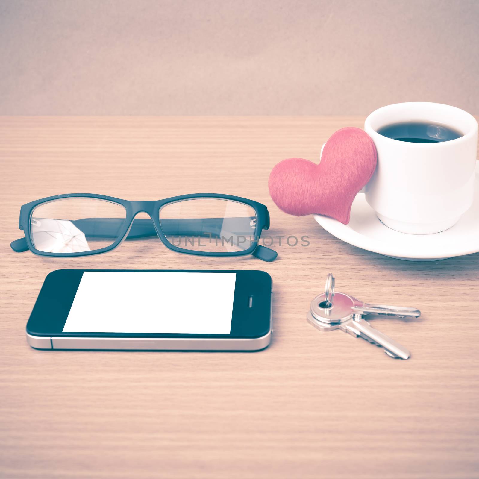 coffee,phone,eyeglasses,key and heart on wood table background vintage style