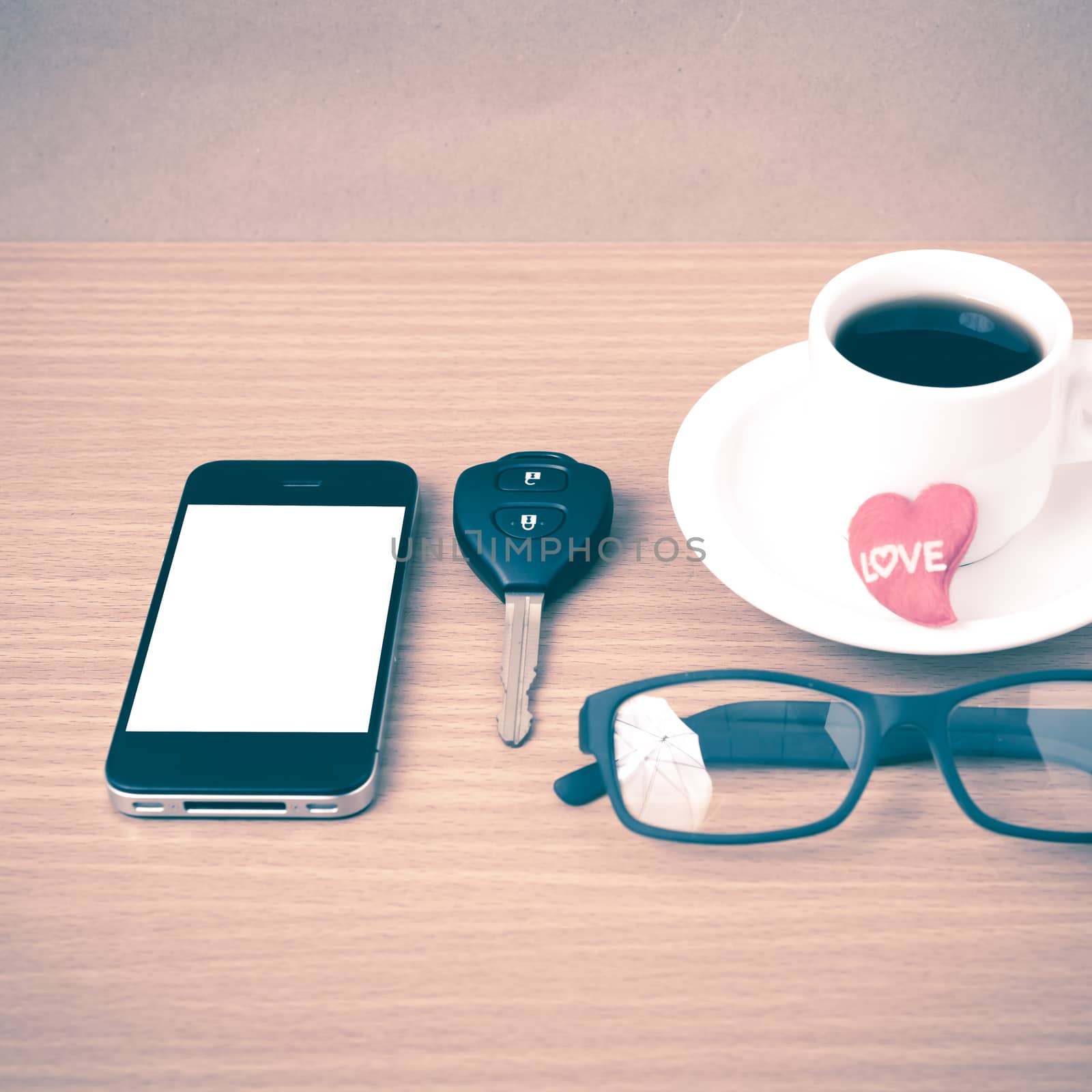 coffee,phone,eyeglasses,car key and heart on wood table background vintage style