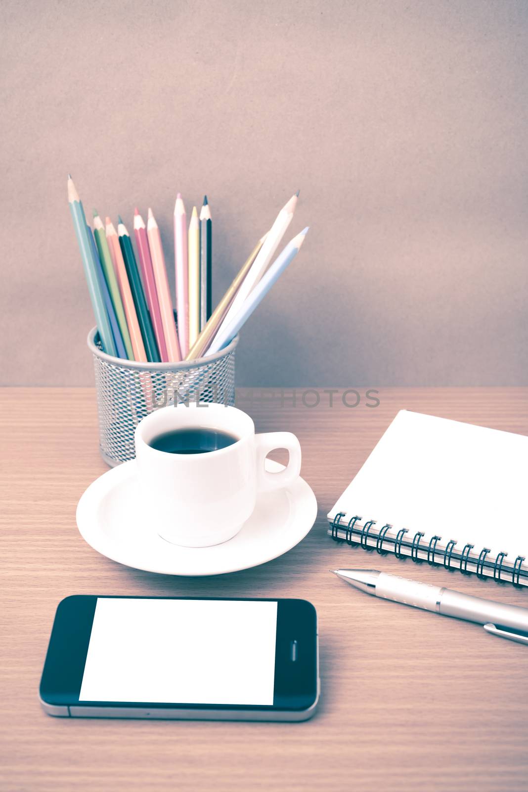 coffe,phone,notepad and color pencil on wood table background vintage style