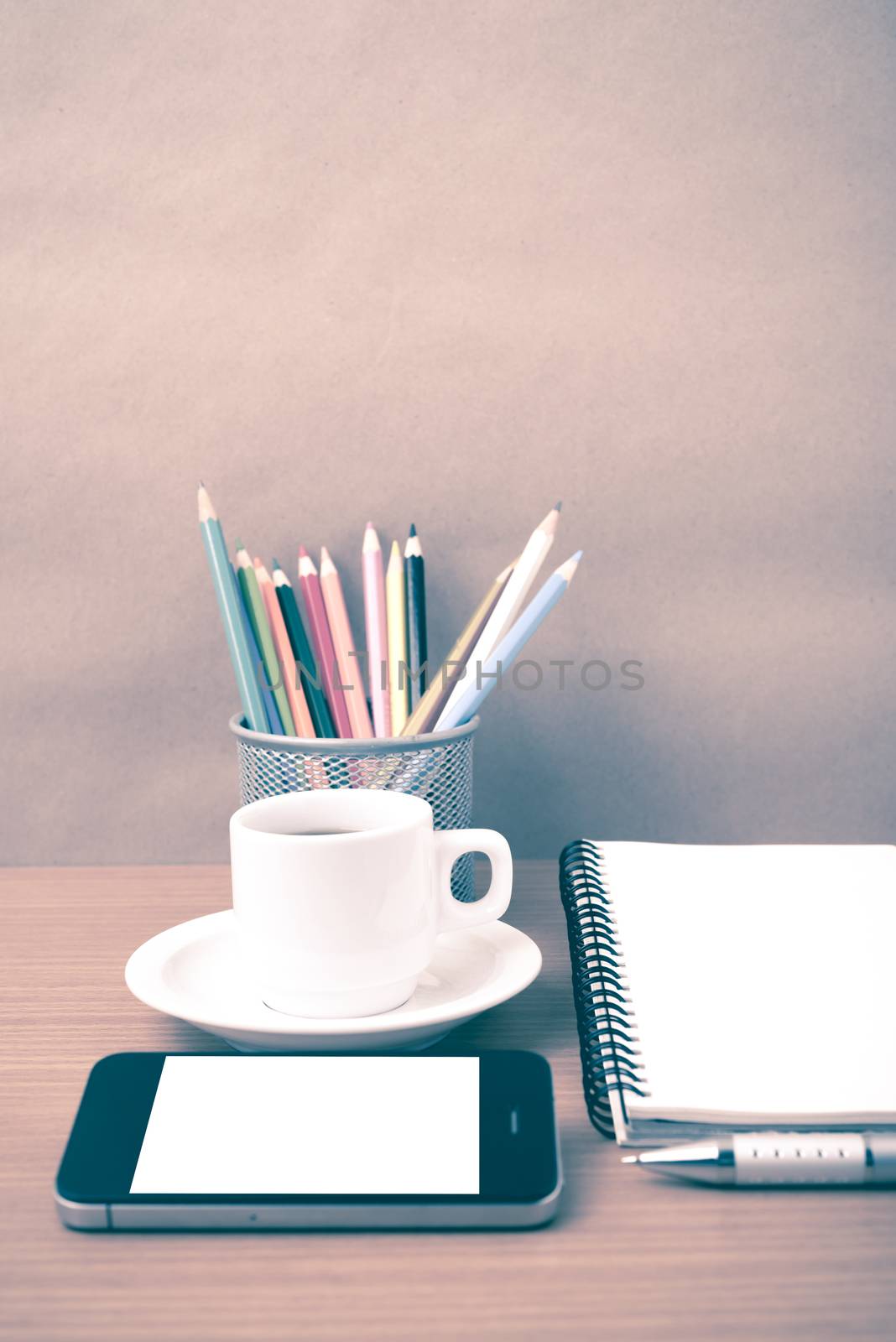 coffe,phone,notepad and color pencil on wood table background vintage style