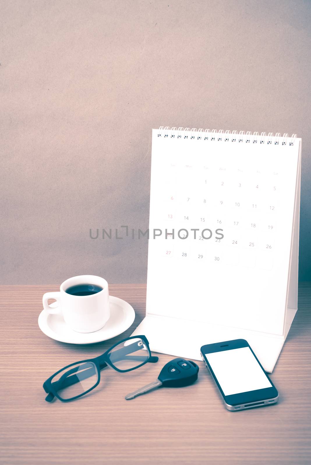 coffee,phone,car key,eyeglasses and calendar on wood table background vintage style