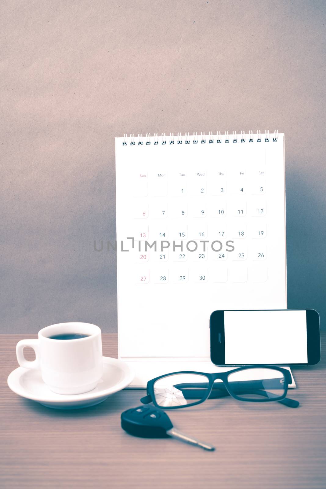 coffee,phone,car key,eyeglasses and calendar on wood table background vintage style