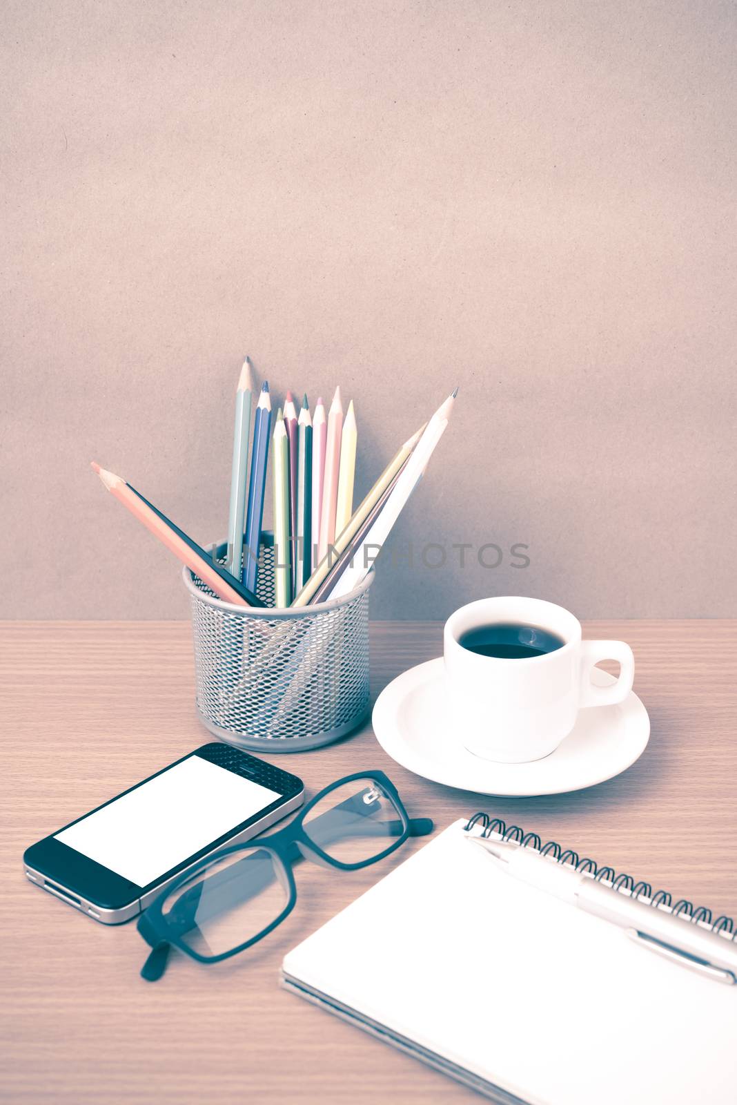 coffee,phone,eyeglasses,notepad and color pencil on wood table background vintage style