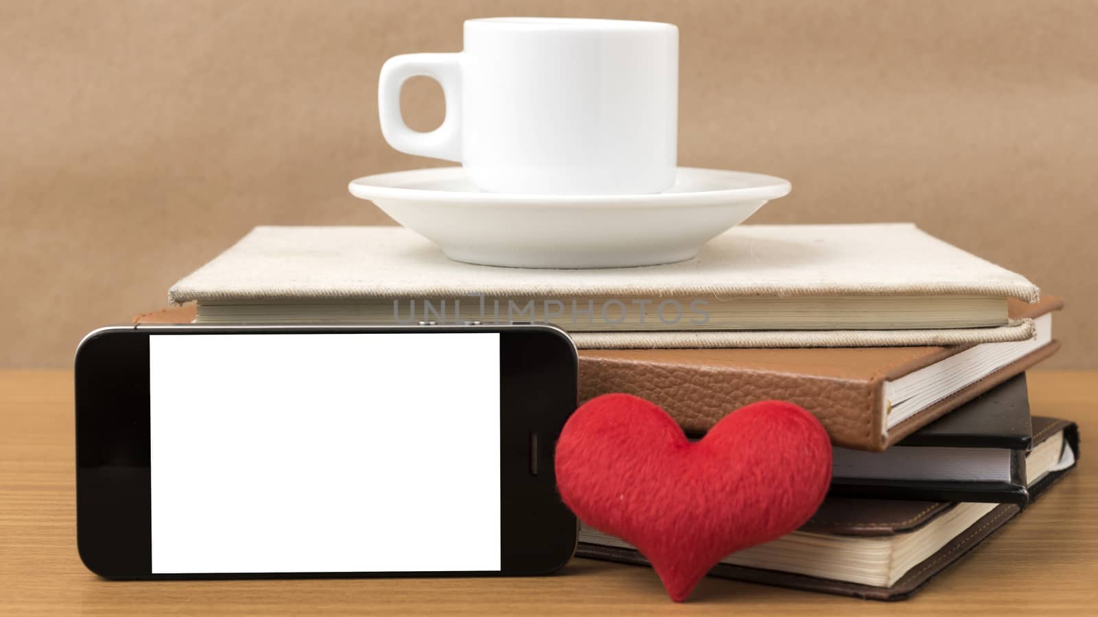 coffee,phone,stack of book and heart on wood table background