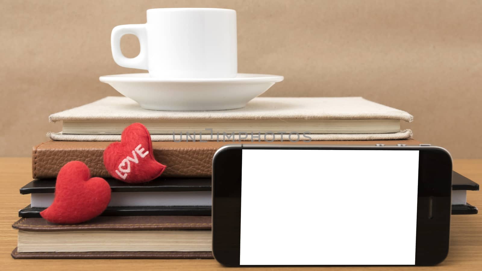 coffee,phone,stack of book and heart on wood table background