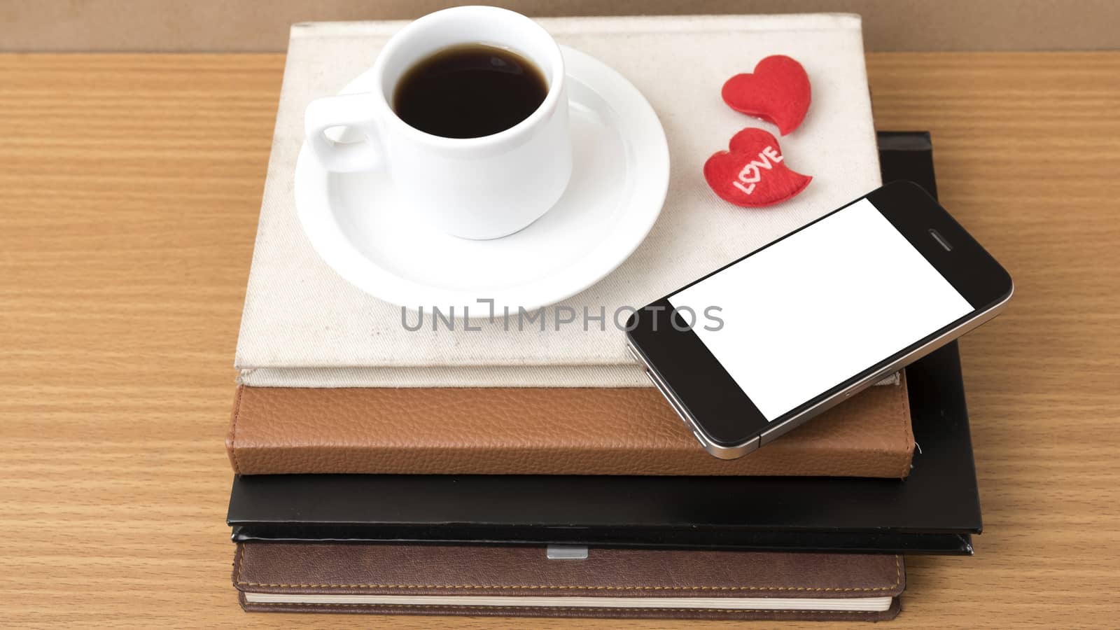 coffee,phone,stack of book and heart on wood table background