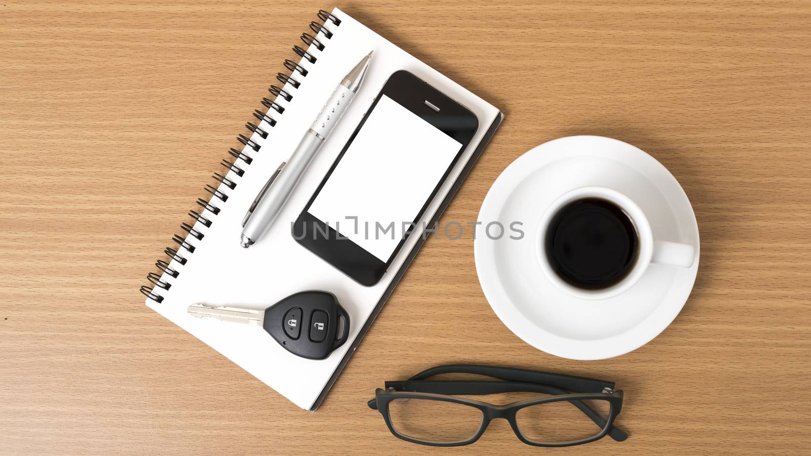 coffee,phone,notepad,eyeglasses and car key on wood table background