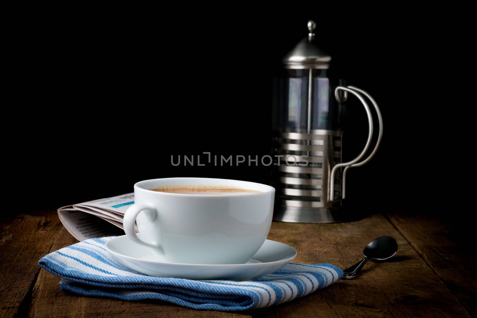 A cup of coffee with cream photographed under artistic lighting.