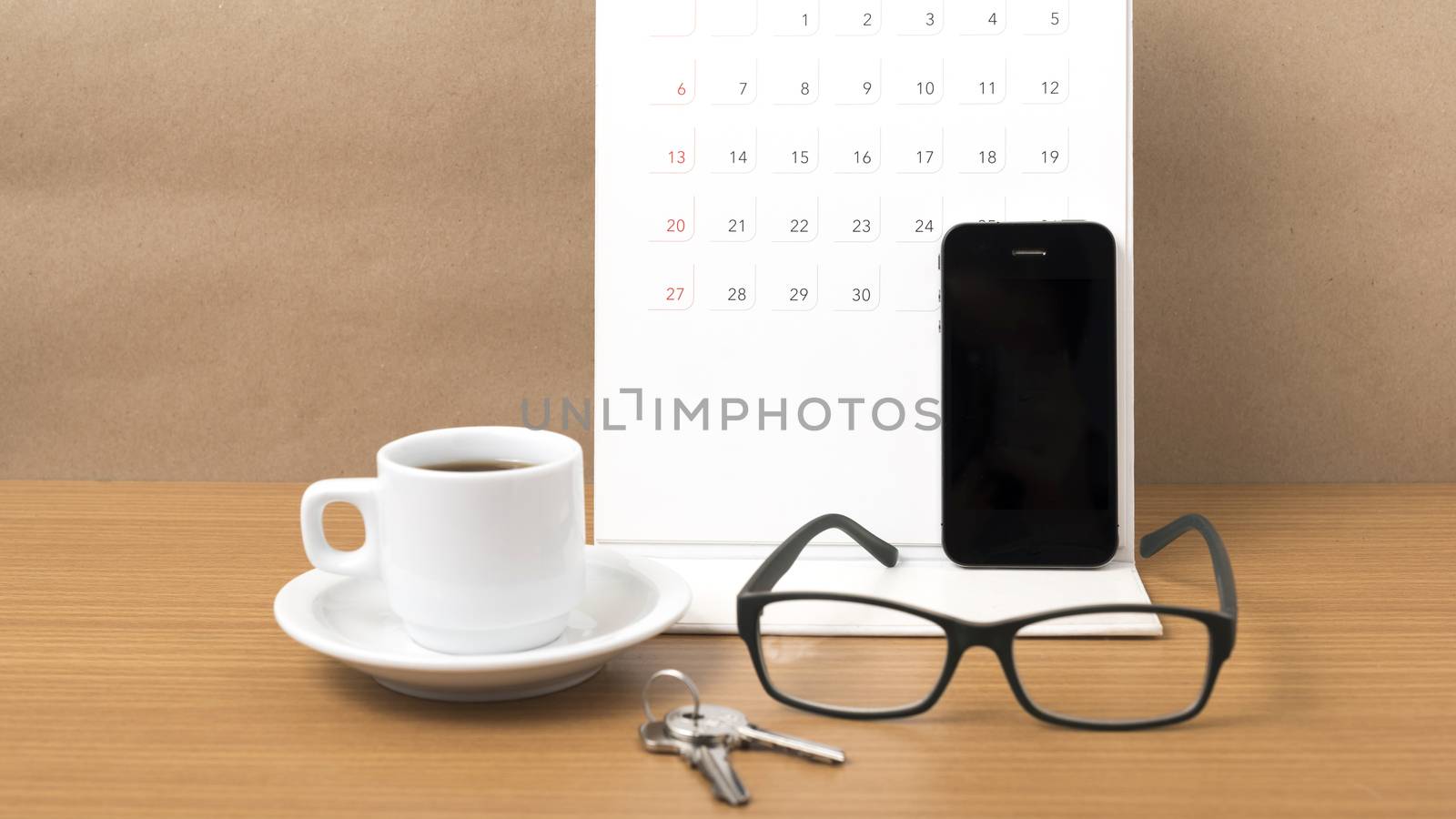 coffee,phone,eyeglasses,calendar and key on wood table background