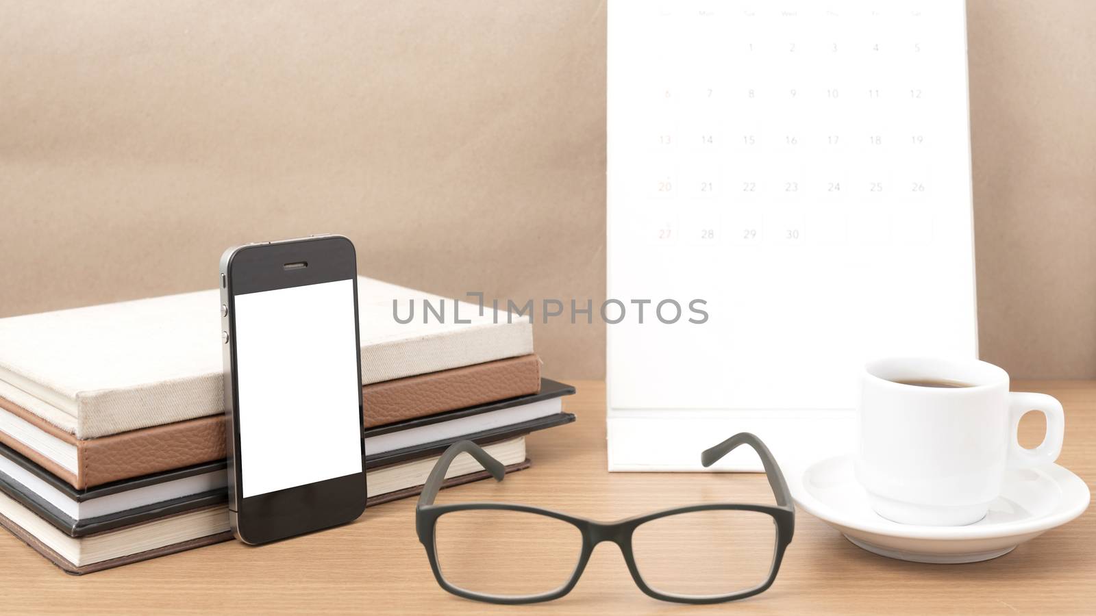 coffee,phone,eyeglasses,stack of book and calendar on wood table background