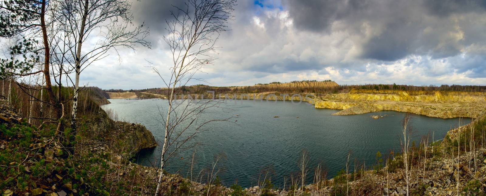 lake with trees growing on the slopes of a cloudy rainy autumn day