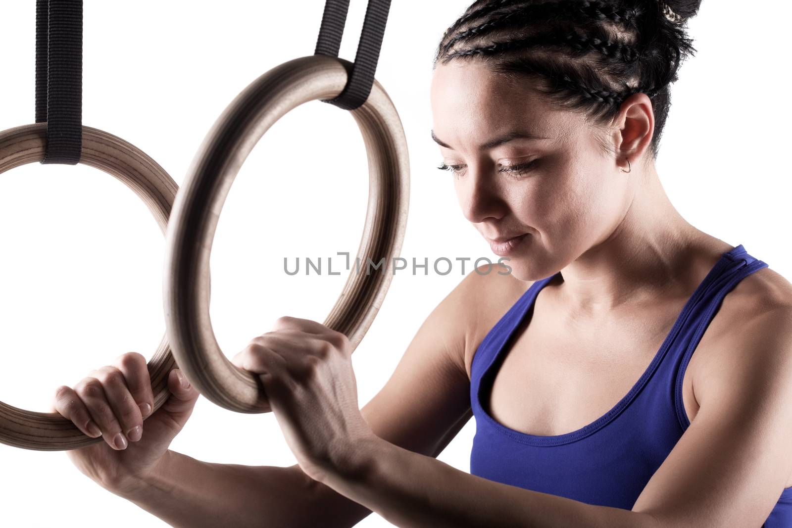 fit girl girl exercising on gymnast rings, against white background