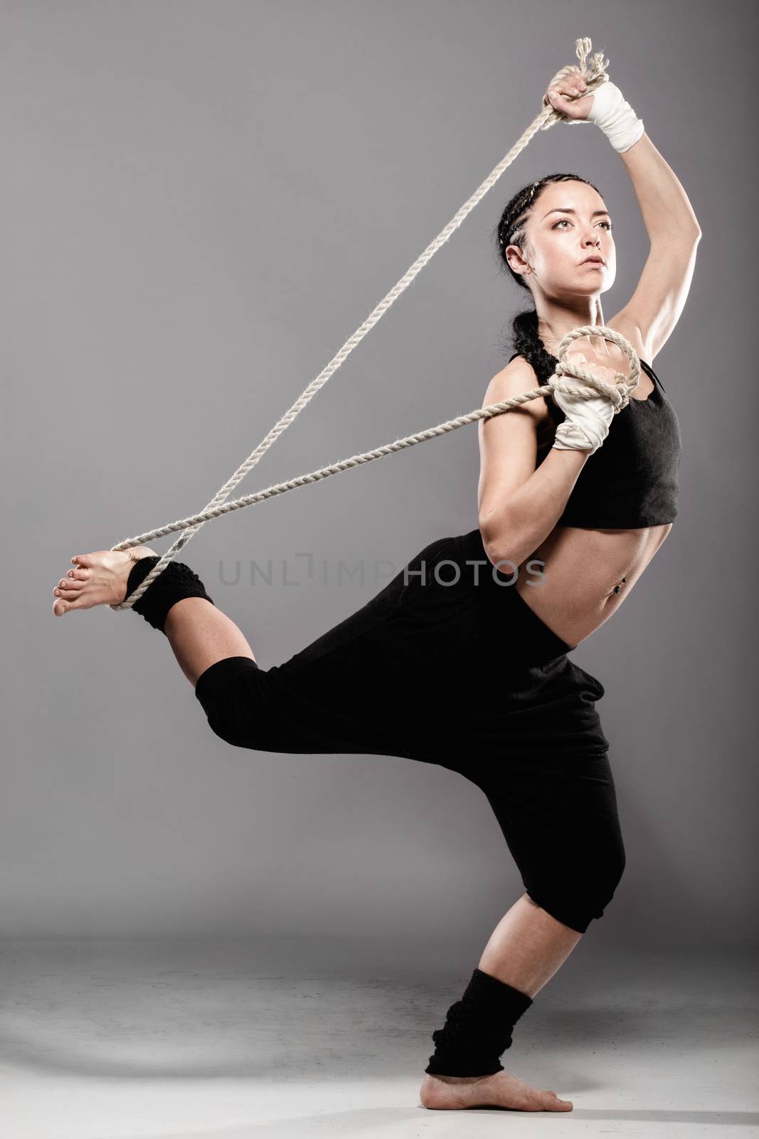 fit girl exercising with a streched rope