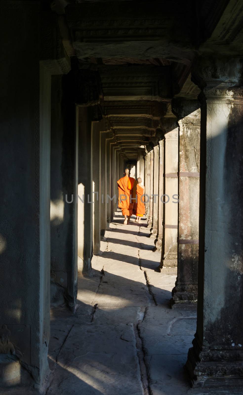 Monks walking along the longest gallery of Angkor Wat temple in Siem Reap, Cambodia