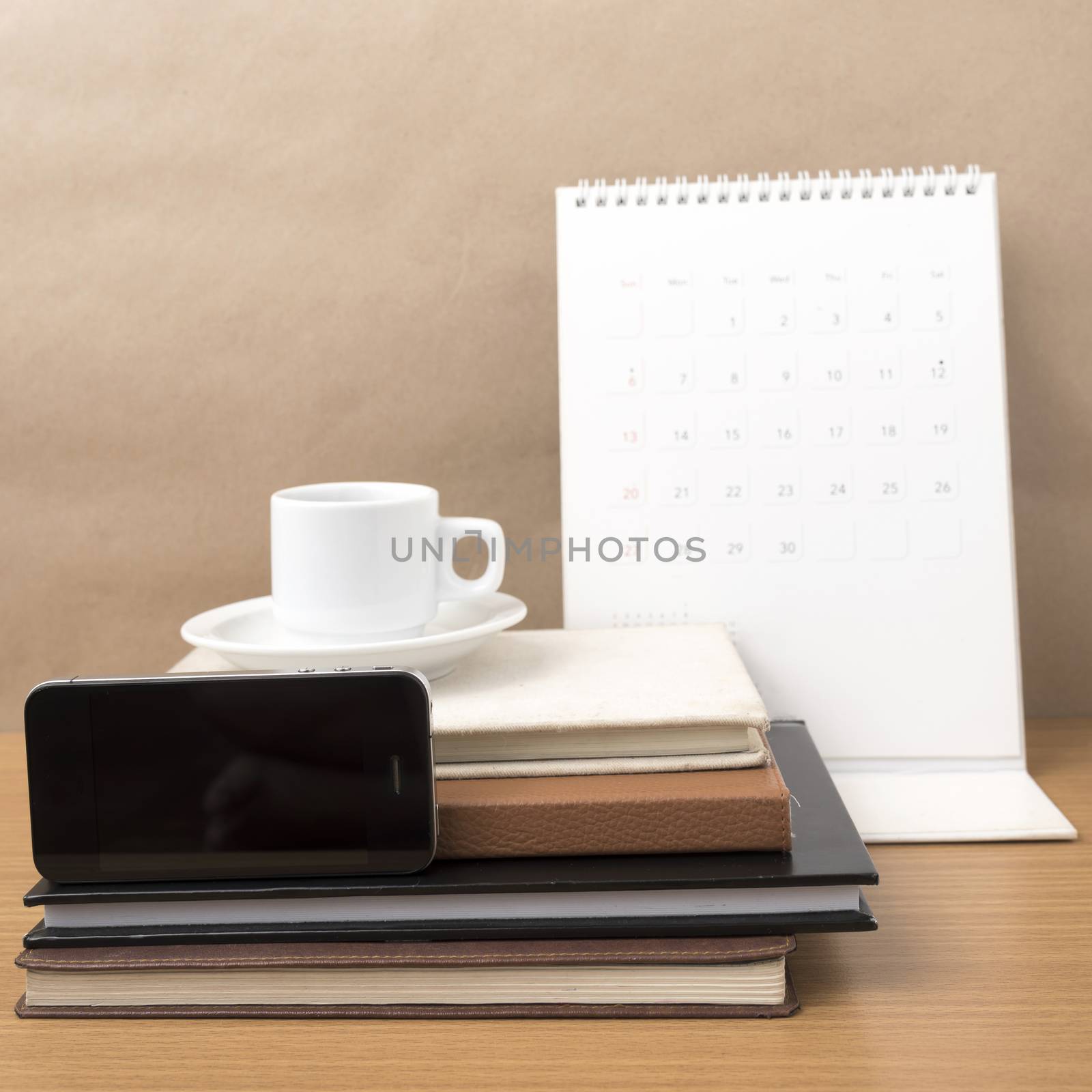 coffee,phone,stack of book and calendar on wood table background