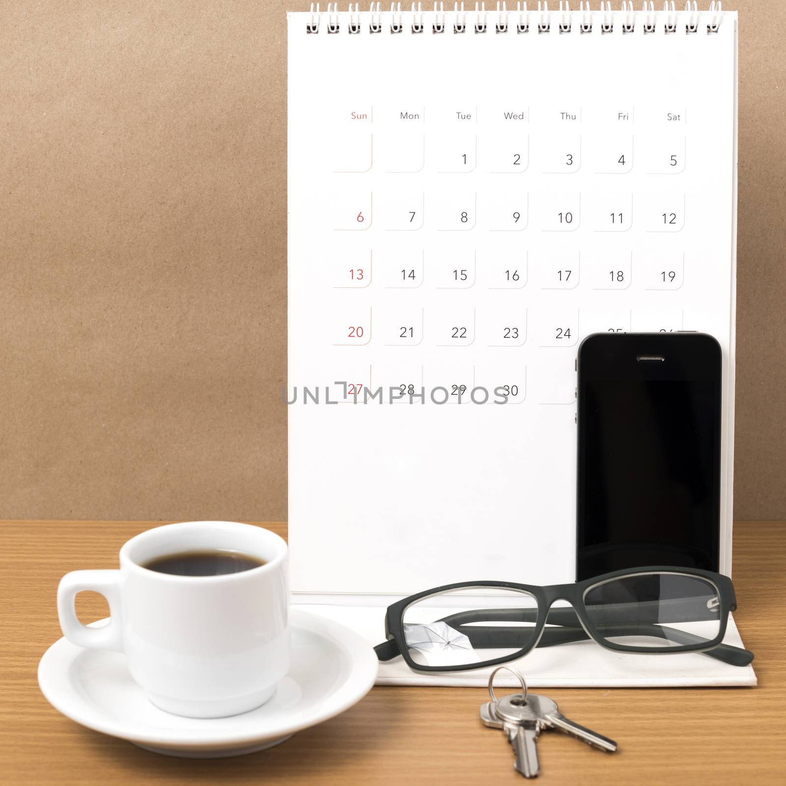 coffee,phone,eyeglasses,calendar and key on wood table background