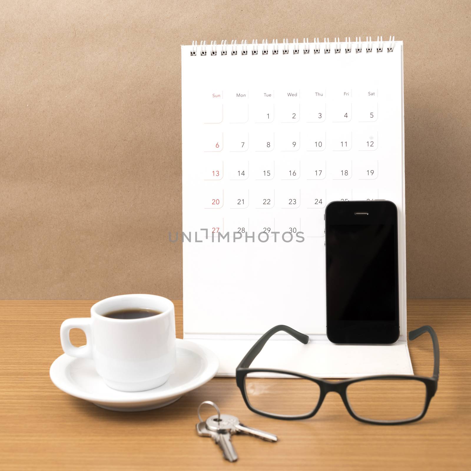 coffee,phone,eyeglasses,calendar and key on wood table background