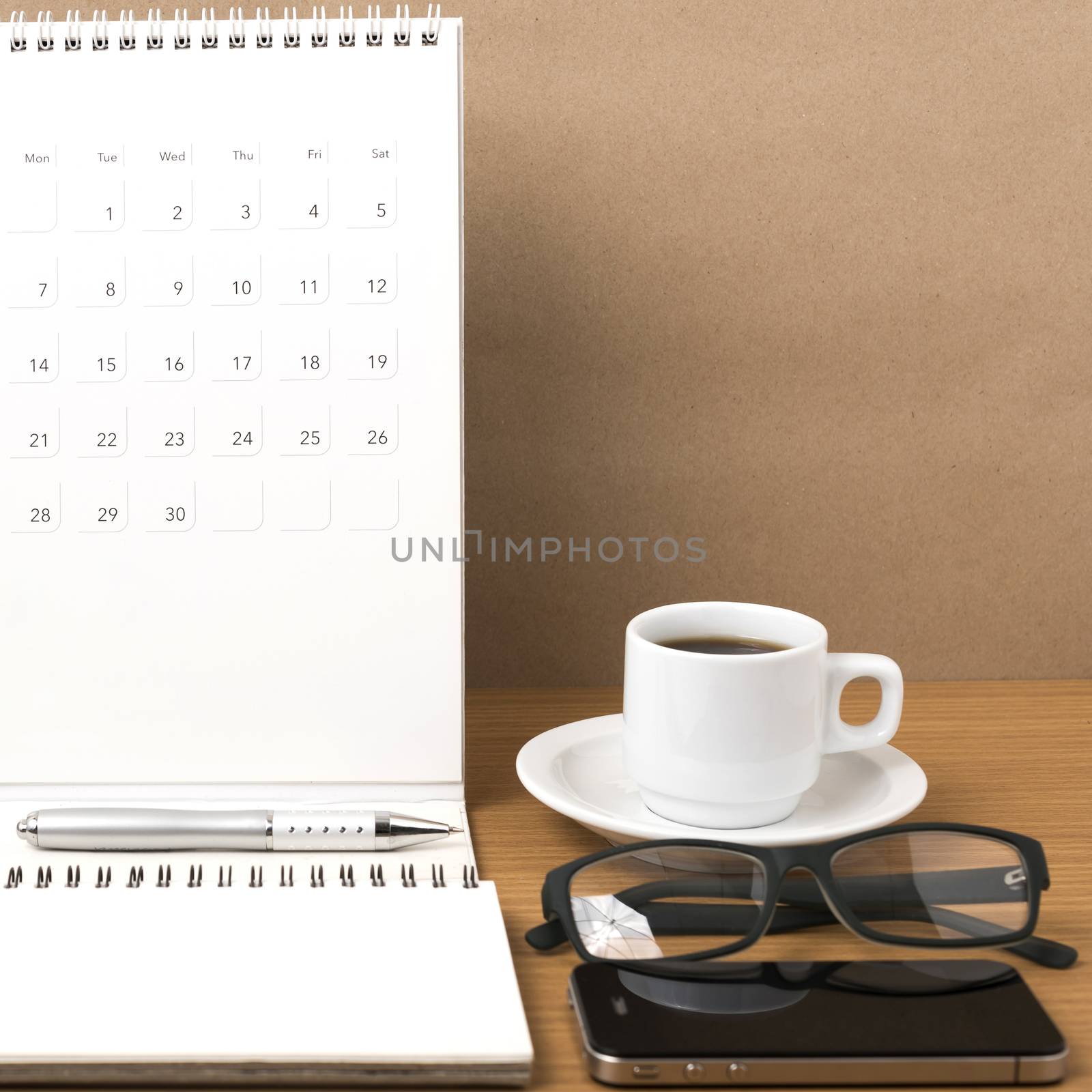 coffee,phone,eyeglasses,notepad and canlendar on wood table background