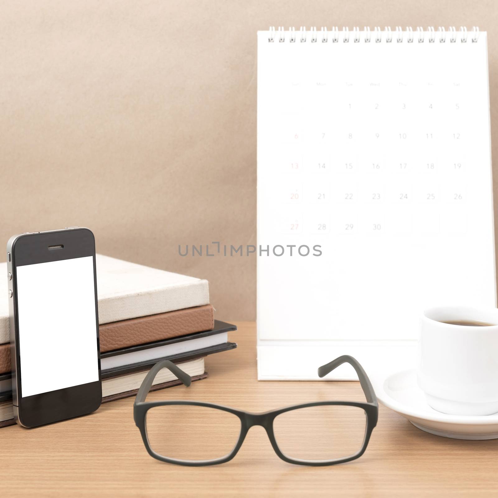 coffee,phone,eyeglasses,stack of book and calendar on wood table background