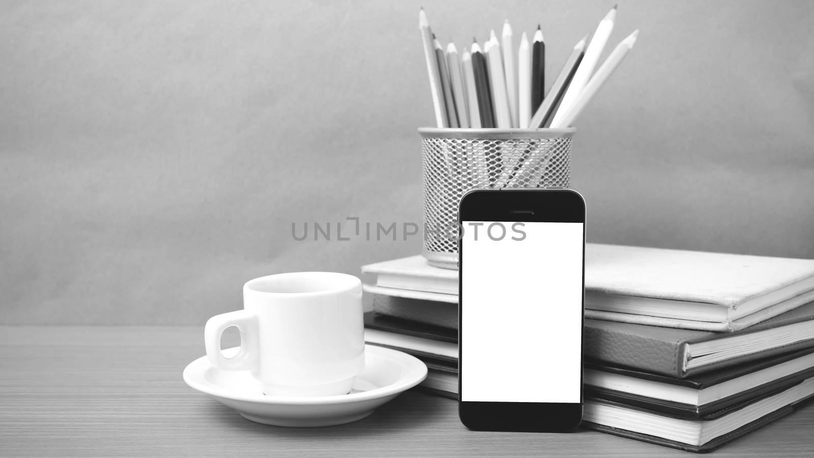 coffee,phone,stack of book and color pencil on wood table background black and white color