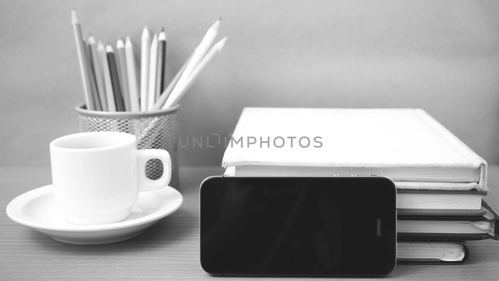 coffee,phone,stack of book and color pencil on wood table background black and white color