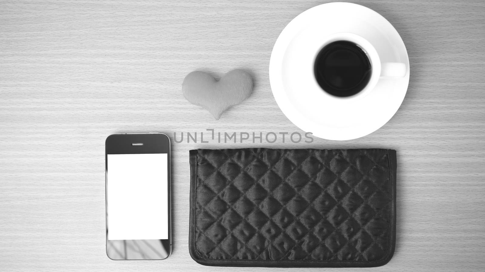 coffee,phone,wallet and heart on wood table background black and white color