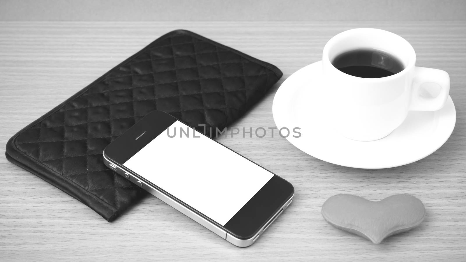 coffee,phone,wallet and heart on wood table background black and white color