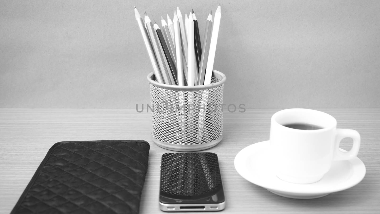 coffee,phone,wallet and color pencil on wood table background black and white color