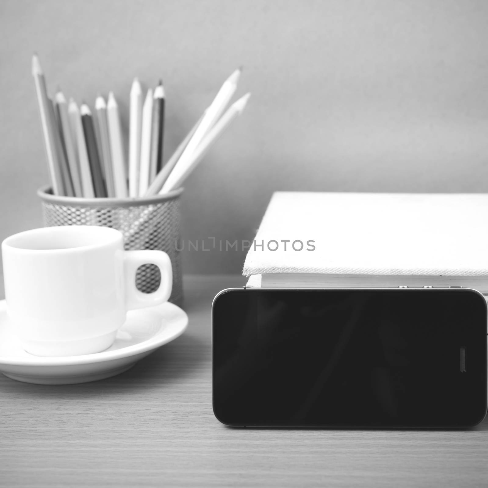 coffee,phone,stack of book and color pencil on wood table background black and white color