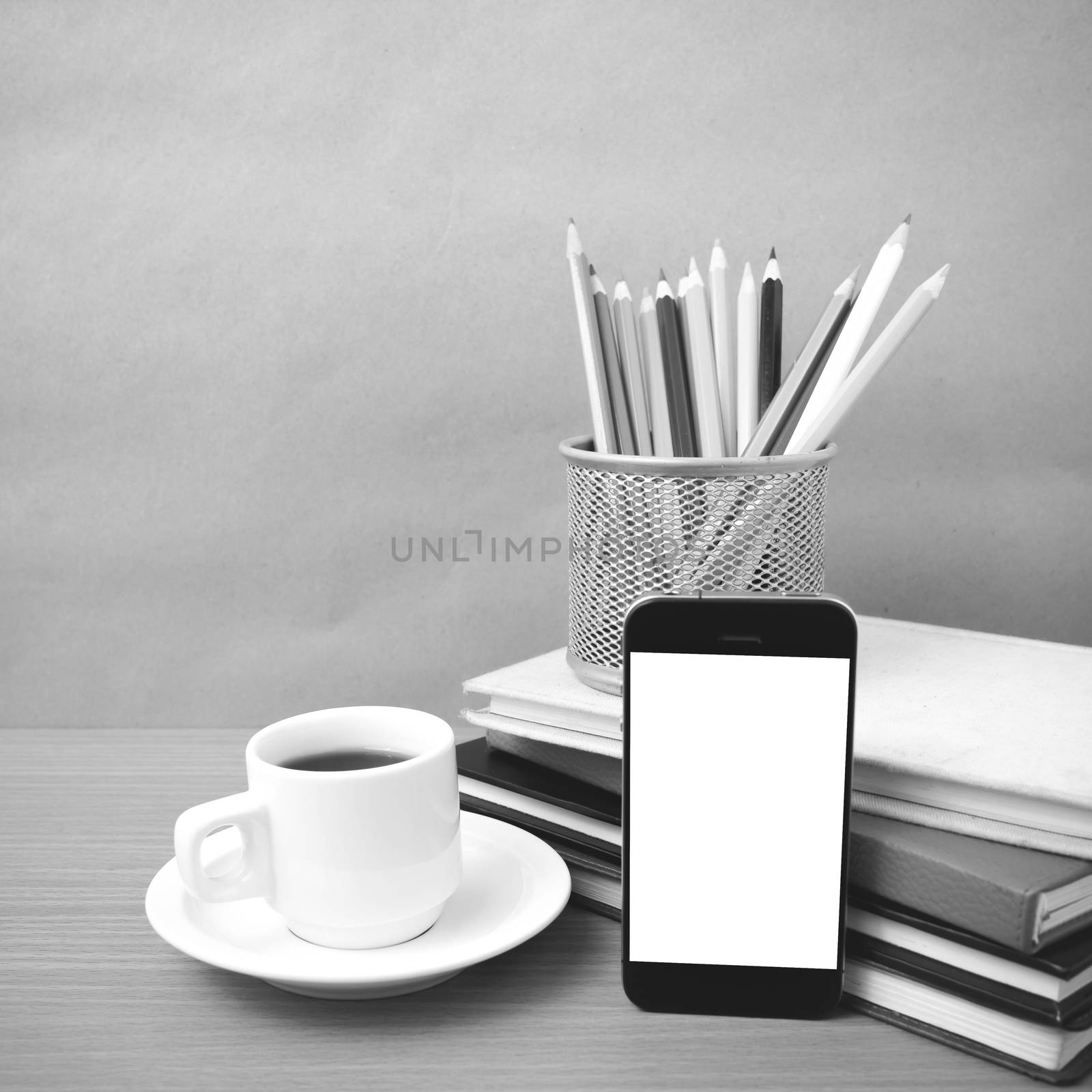 coffee,phone,stack of book and color pencil on wood table background black and white color