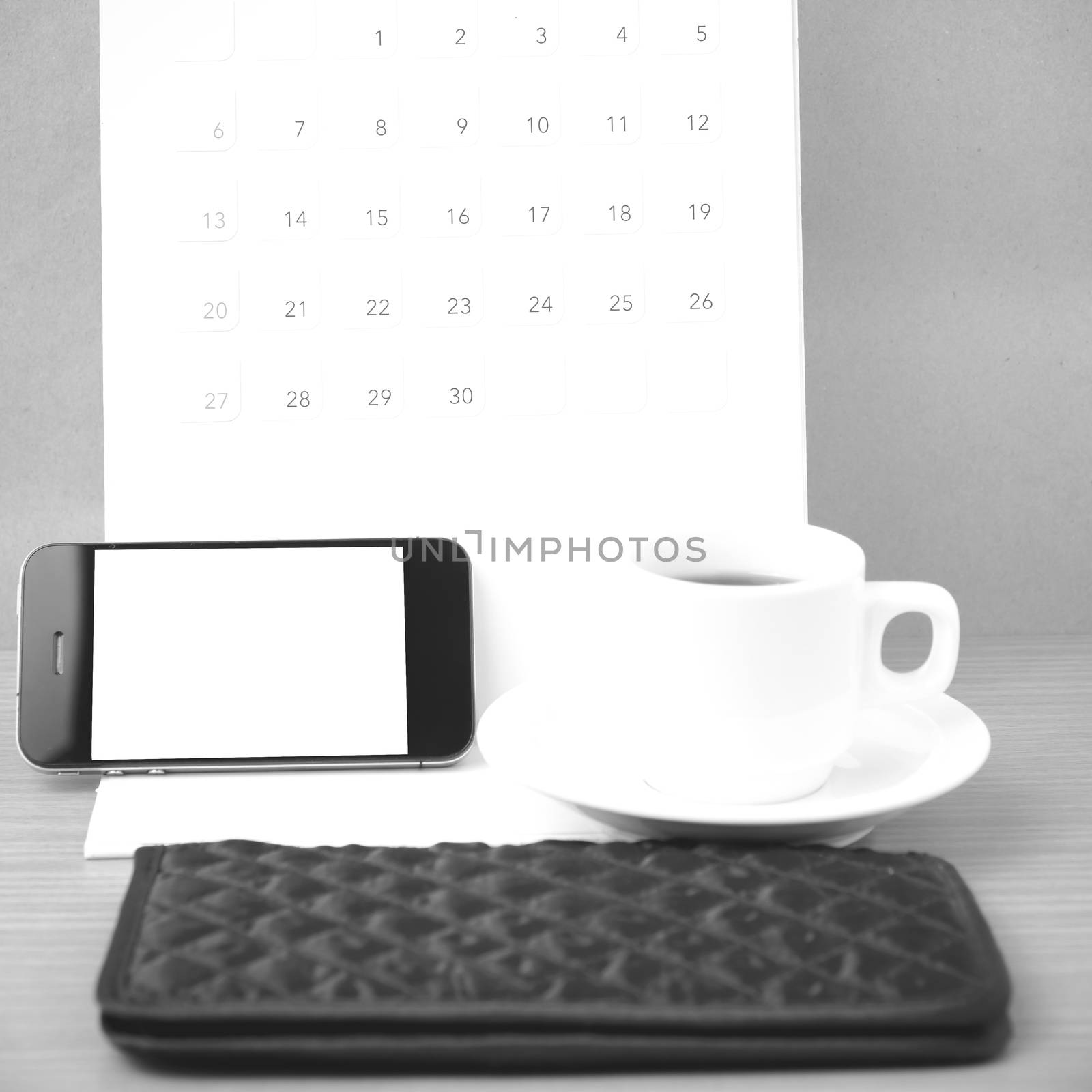 coffee,phone,wallet and canlendar on wood table background black and white color