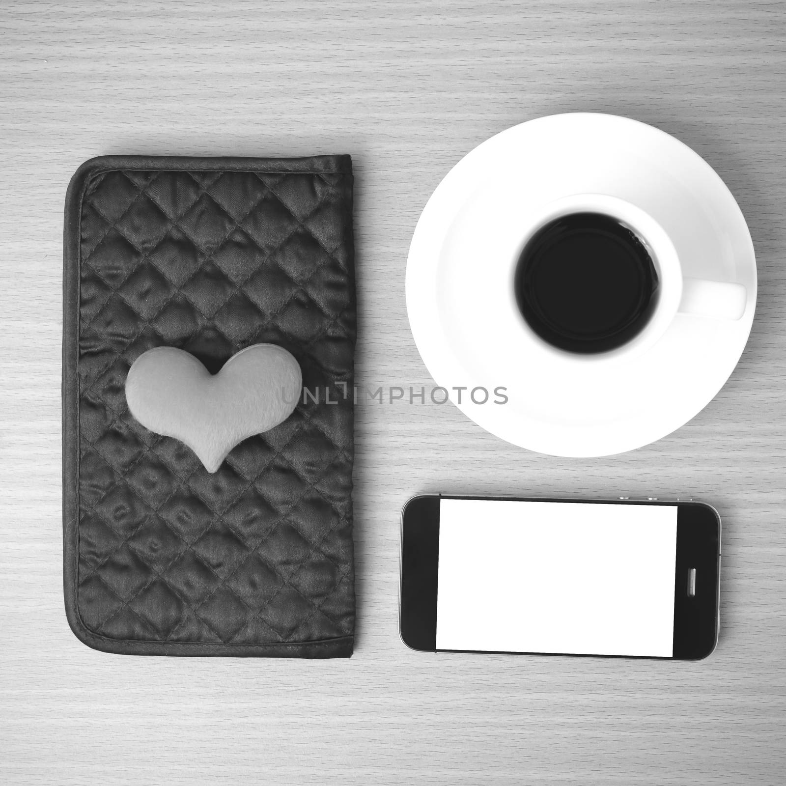 coffee,phone,wallet and heart on wood table background black and white color