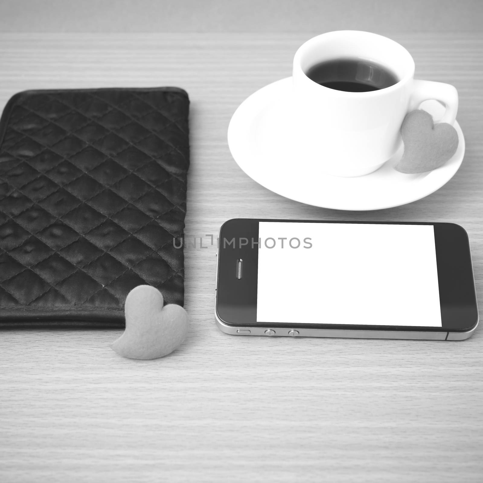 coffee,phone,wallet and heart on wood table background black and white color