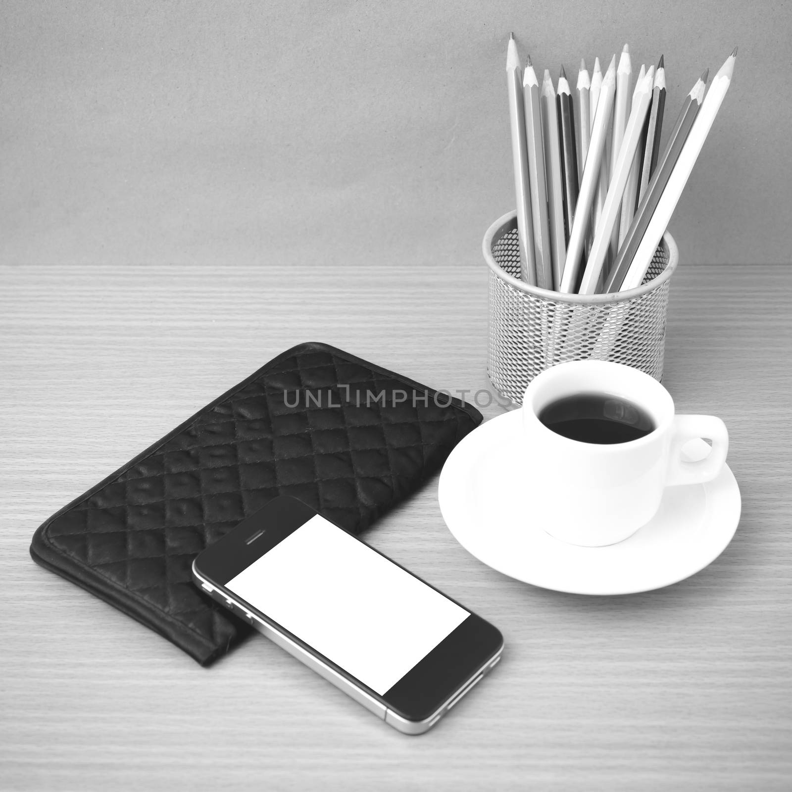 coffee,phone,wallet and color pencil on wood table background black and white color