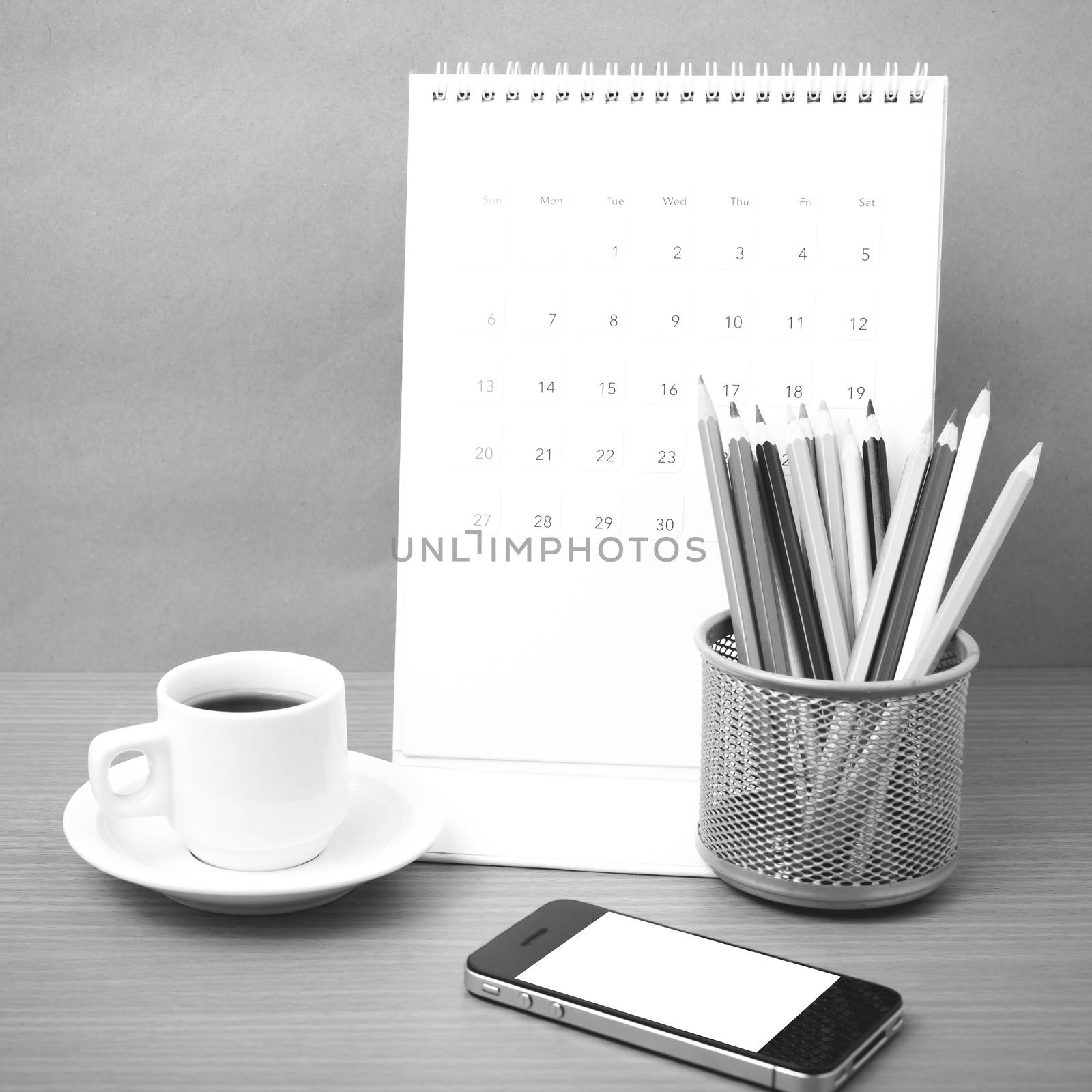coffee,phone,calendar and color pencil on wood table background black and white color