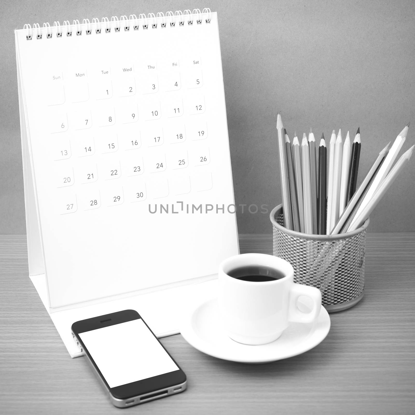 coffee,phone,calendar and color pencil on wood table background black and white color