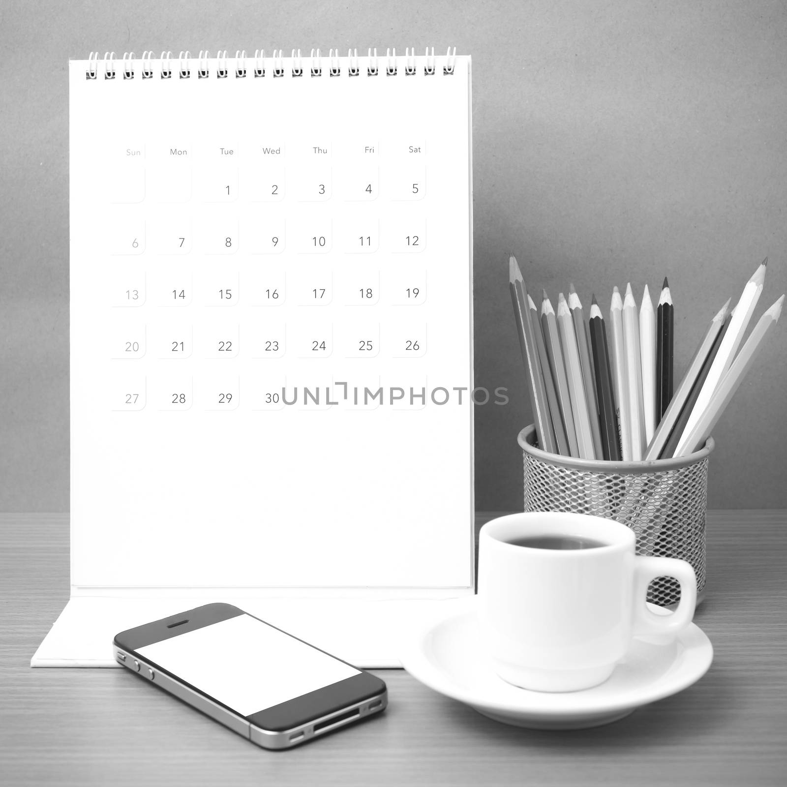 coffee,phone,calendar and color pencil on wood table background black and white color