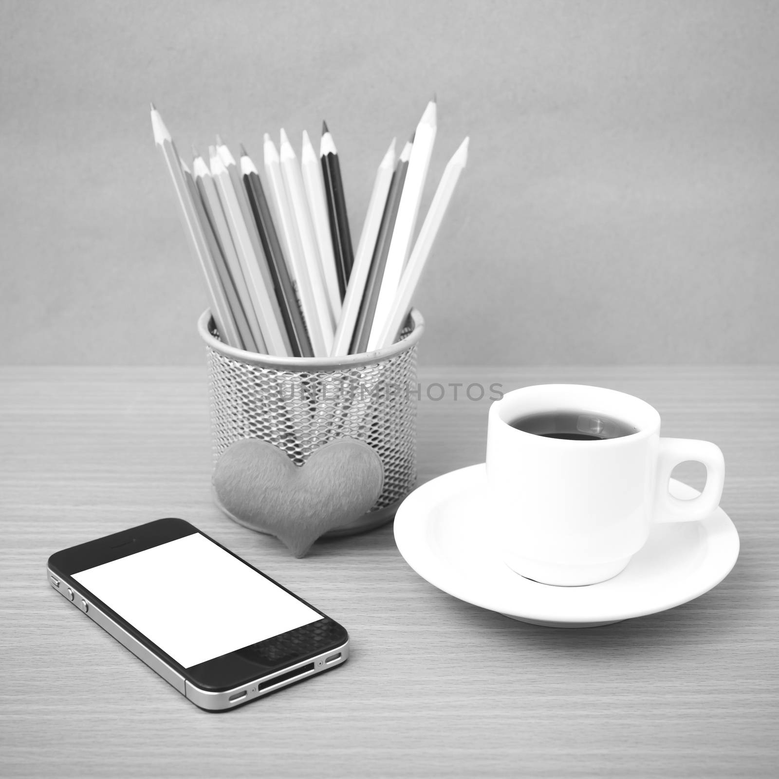 coffee,phone,color pencil and heart on wood table background black and white color