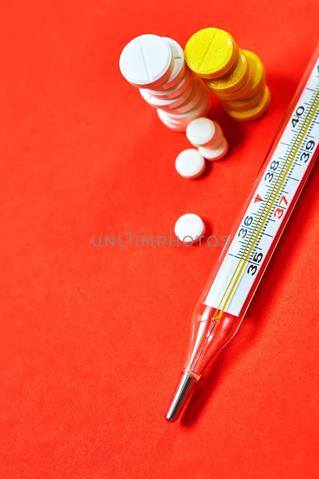 Mercury thermometer and medical pills on background by sarymsakov