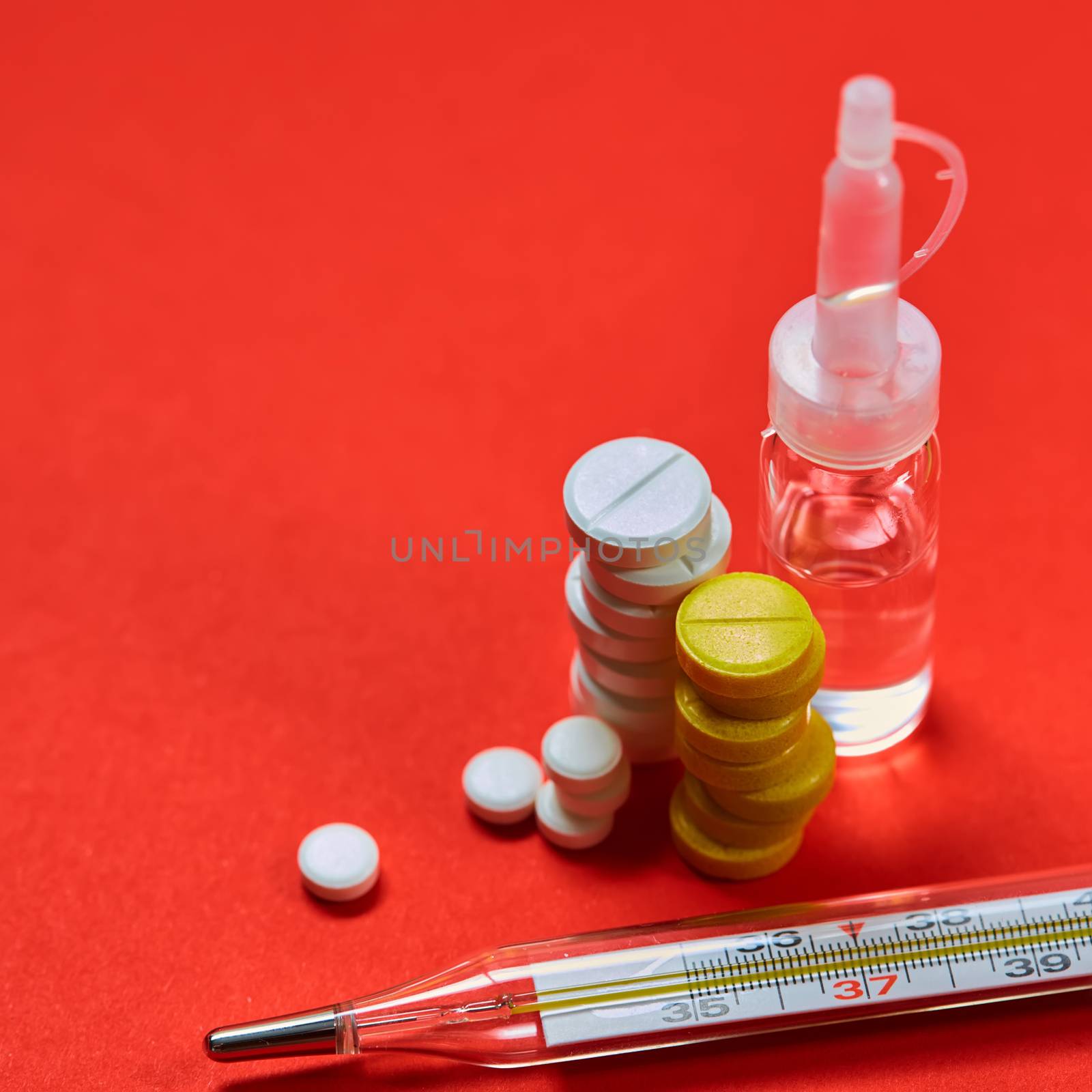 Mercury thermometer and medical pills on background by sarymsakov