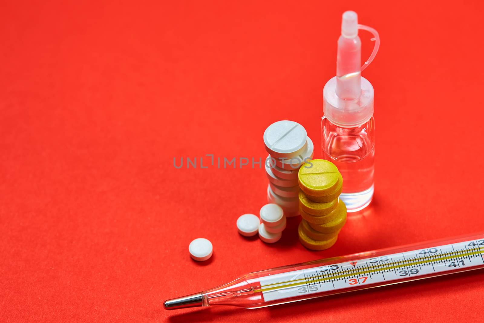 Mercury thermometer and medical pills on background by sarymsakov