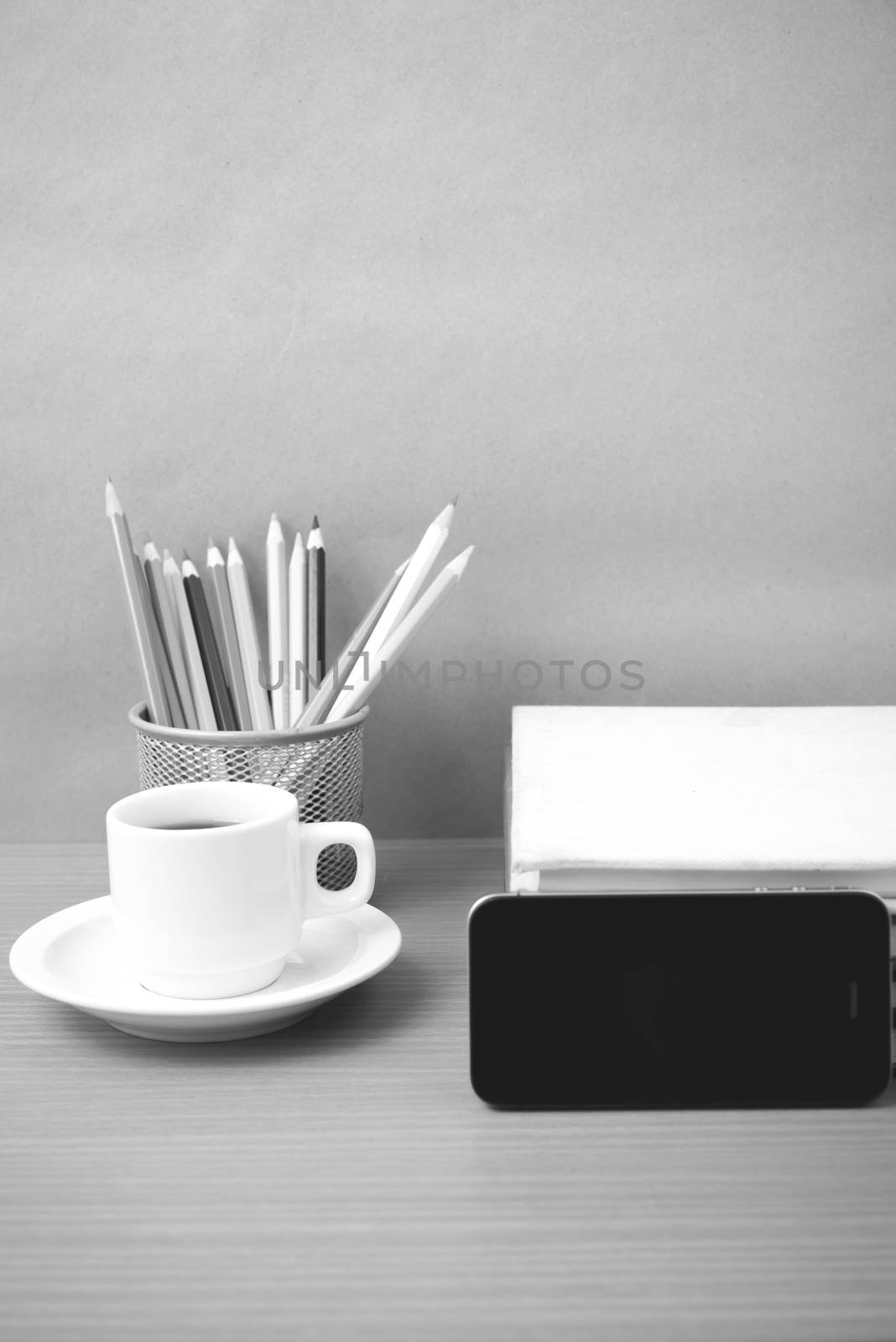 coffee,phone,stack of book and color pencil on wood table background black and white color