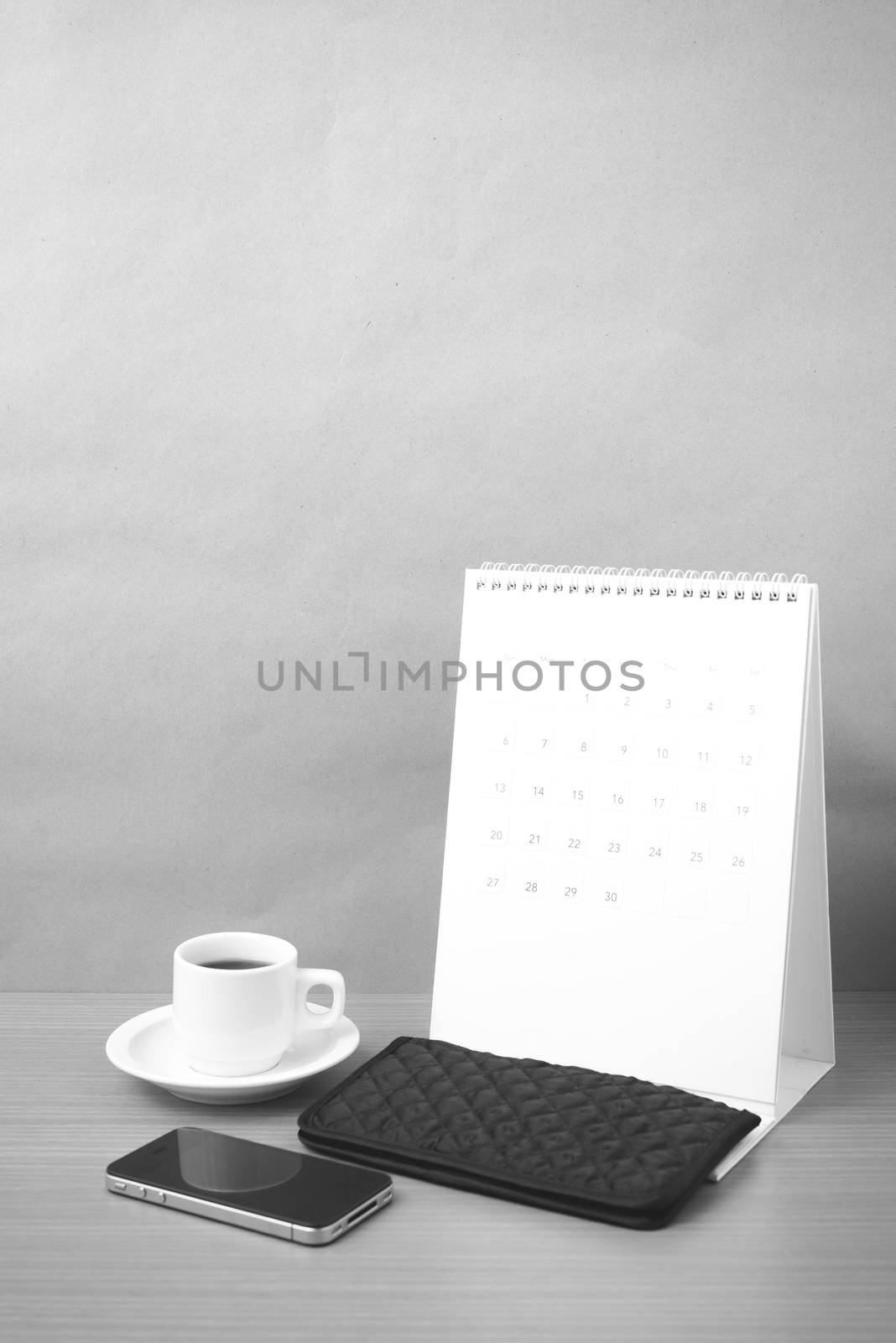 coffee,phone,wallet and canlendar on wood table background black and white color