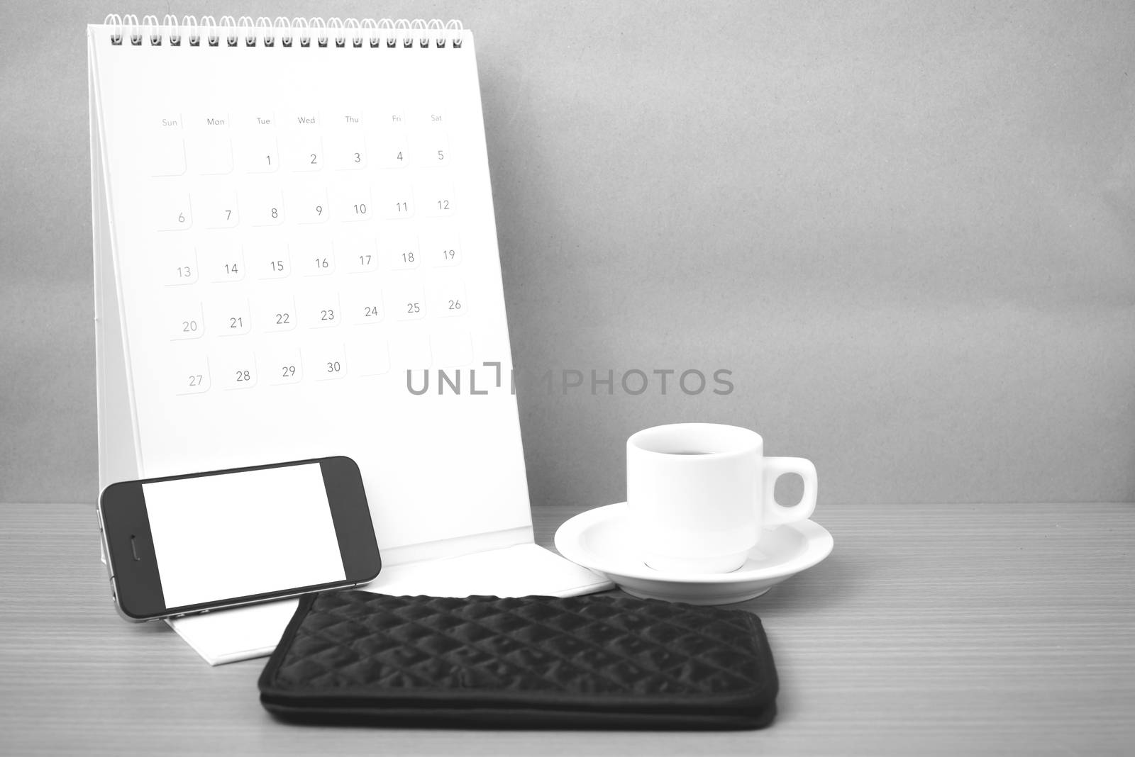 coffee,phone,wallet and canlendar on wood table background black and white color